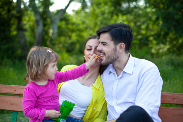 istock Happy Family Sitting on Bench in Woods 1534206777