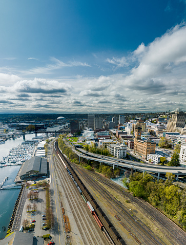 An aerial view of rail cars and tracks.  The city of Tacoma is visible in the background.  This is in the Port of Tacoma.