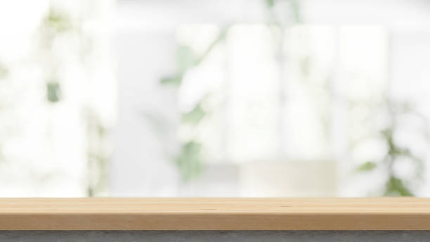 istock Wooden table on the blurred light abstract home with plants and windows background bokeh, special empty place for productoin desplacement and presentation 1534216287