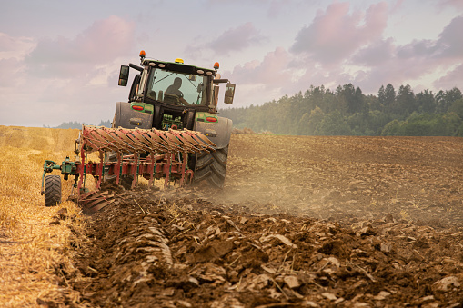 plowing straw field with heavy tractor