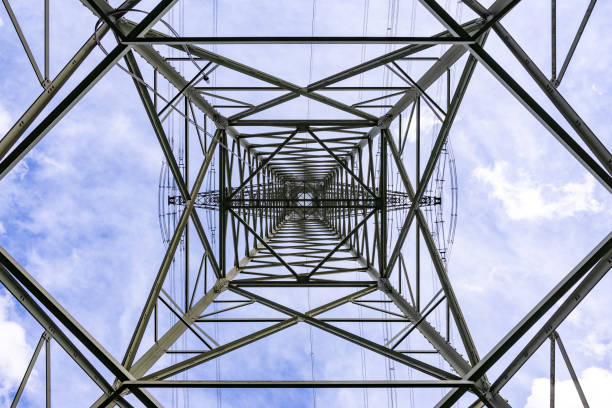 High voltage pole steel construction with wires from below stock photo