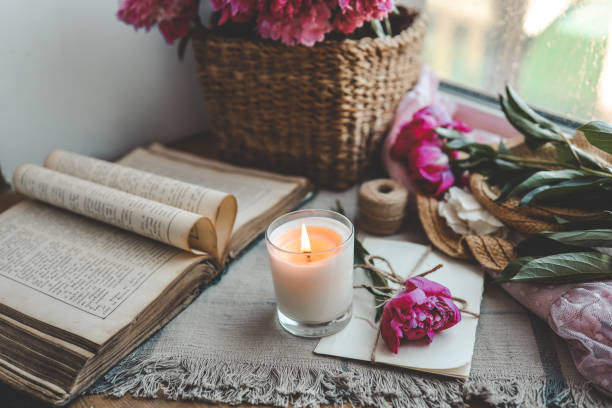 istock Burning candle and pink peonies, vintage aesthetic 1534232192