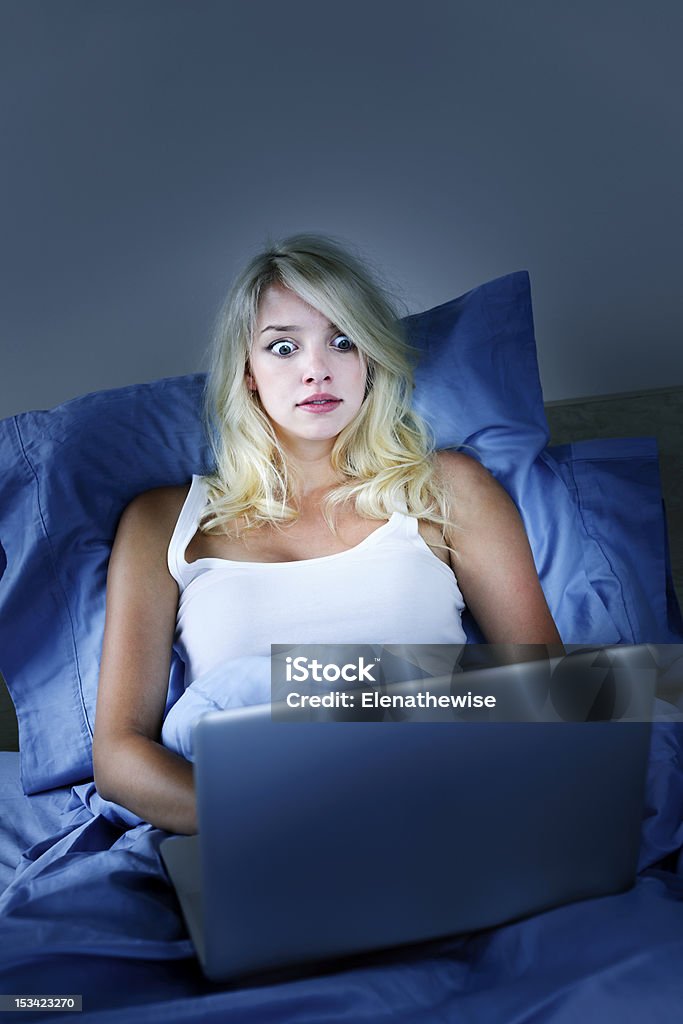 Spaventato donna con computer a notte - Foto stock royalty-free di Computer portatile