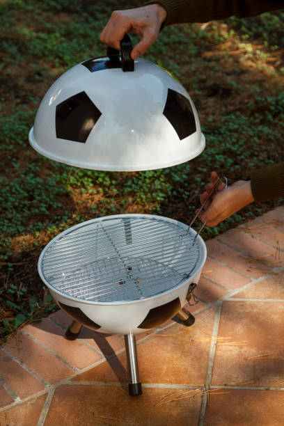 istock Hand open lid on round grill in yard 1534234800