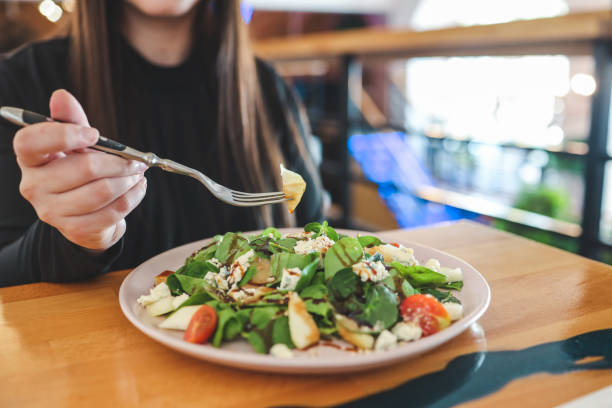 istock Woman's hands with Caesar salad on table in restaurant 1534262708