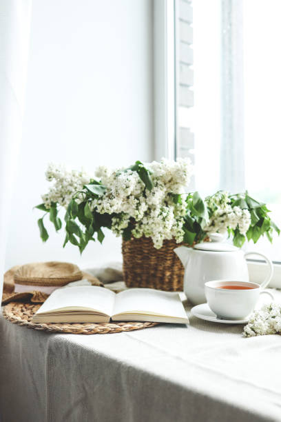 istock Open book, cup of tea and teapot, white lilac basket and hat, summer composition 1534273315