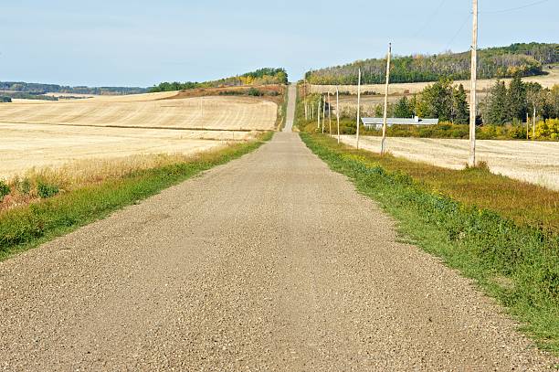 istock Gravel road and harvested grain fields 153428396