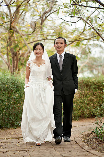Asian couple dressed in traditional western style wedding clothes.