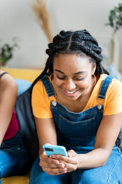 istock Woman smiling while using mobile phone at home. 1534378576