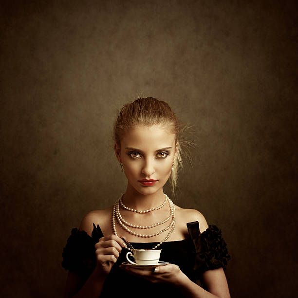 Pretty young woman relaxing with a cup of coffee. Nostalgic retro style, toned image, added real film grain for the mood. 