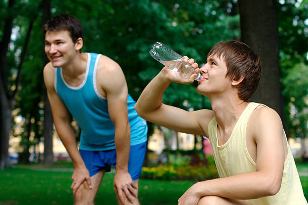 istock Two young sportmen resting outdoors 153440268