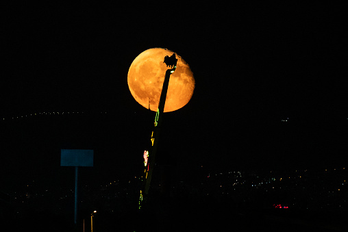 The image of the rocket, which is one of the luna park game tools, combined with the moon. Taken with a tele lens at moonrise.