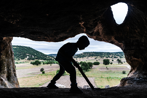 Boy having fun with a stick in the cave in the Phrygian Valley. Today, the region, which is spread over the region within the borders of Eskişehir, Kütahya and Afyon provinces and contains historical ruins and ancient artifacts bearing traces of Phrygian civilization, is called the Phrygian Valleys.