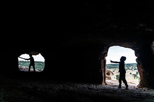 Brothers having fun with sticks in cave in Phrygian Valley. Today, the region, which is spread over the region within the borders of Eskişehir, Kütahya and Afyon provinces and contains historical ruins and ancient artifacts bearing traces of Phrygian civilization, is called the Phrygian Valleys.