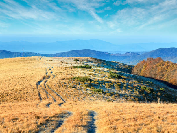 istock Morning autumn mountain road view and Cross. 1534421714
