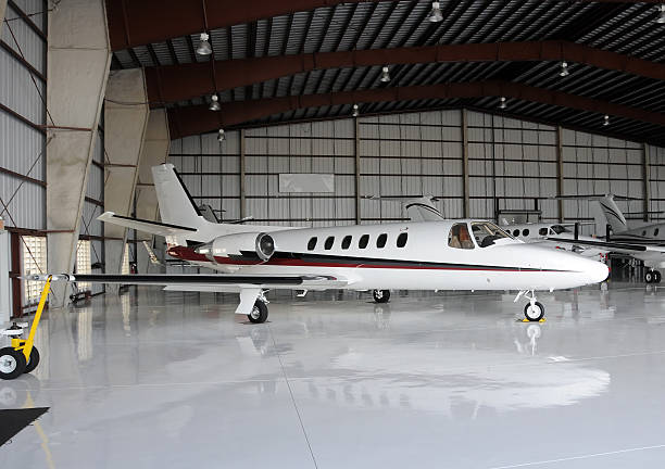 Private jet in hangar Luxury private jet in hangar between flights airplane hangar stock pictures, royalty-free photos & images