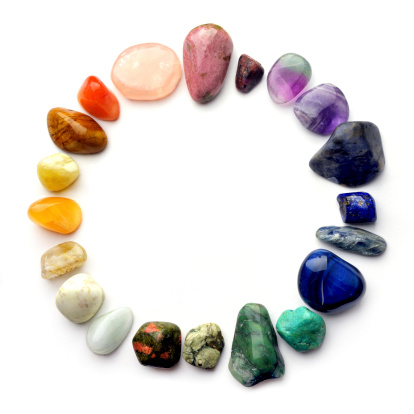 Semiprecious gemstones of various colors in circle on white background