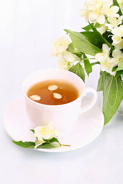 Cup of jasmine tea and flowers stock photo