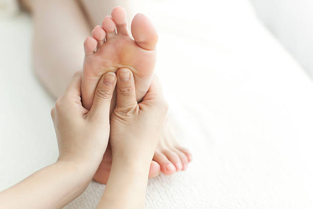 l'esthéticienne qui massages de pied - reflexology pedicure massaging human foot photos et images de collection