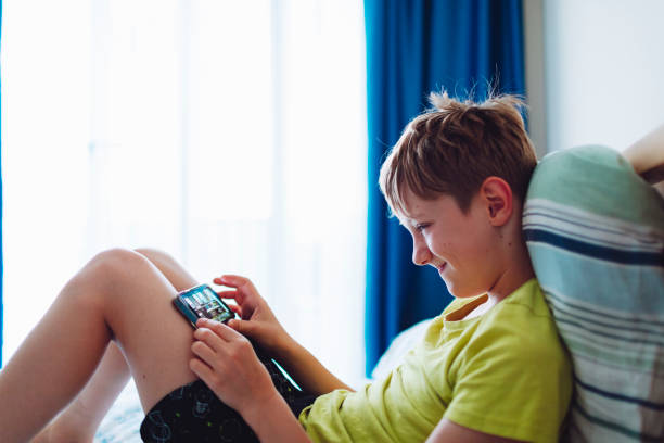 istock School age boy playing video game using mobile at home lying down on bed 1534490612
