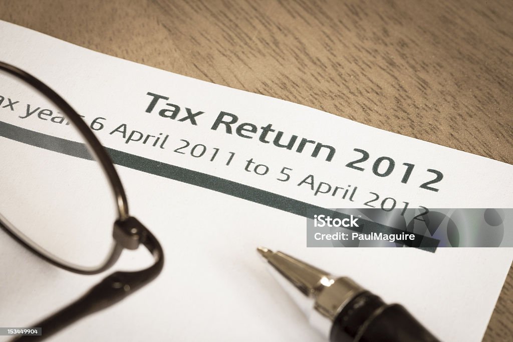 Tax return 2012 UK Income tax return form for 2012 on a desk with pen and spectacles 2012 Stock Photo