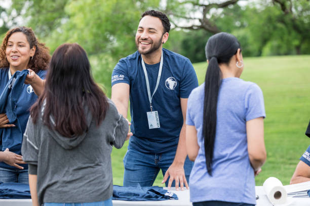 Young adult male shakes hands with the female volunteer stock photo