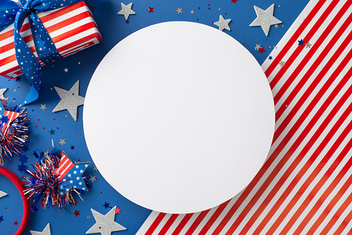Celebrating spirit of freedom. From top view, immerse yourself in allure of party accessories, headband, stars, confetti, giftbox on American flag background with empty circle for text or promo use