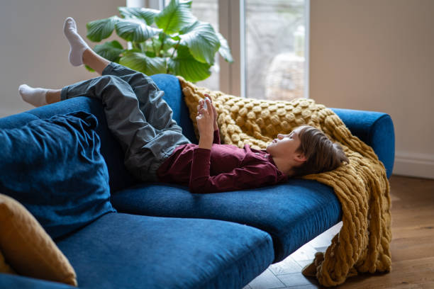 istock Relaxed child boy lies on couch playing online virtual video game, use app on internet on smartphone 1534531897