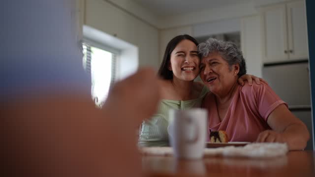 Young woman talking to grandmother in the dining room at home
