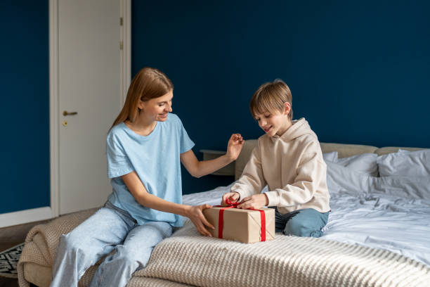 istock Happy kid son unwrapping gift box feeling excited getting present from caring loving mother 1534532495
