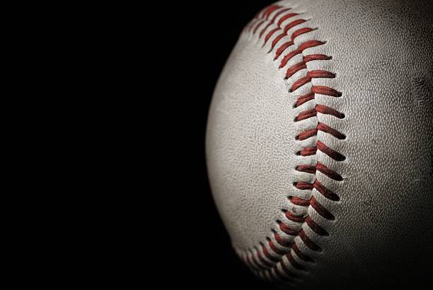 Roughed looking baseball in front of a black background Close up of a baseball over a black background baseball sport photos stock pictures, royalty-free photos & images