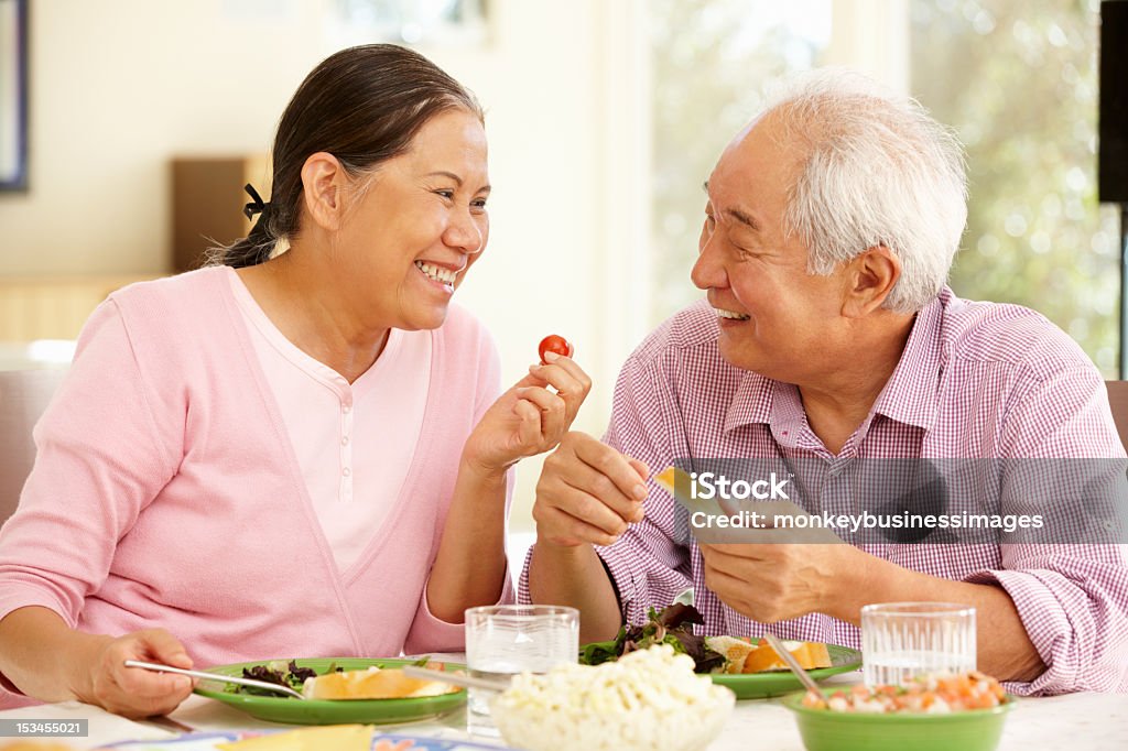 Senior pareja compartir una comida asiática en casa - Foto de stock de Tercera edad libre de derechos