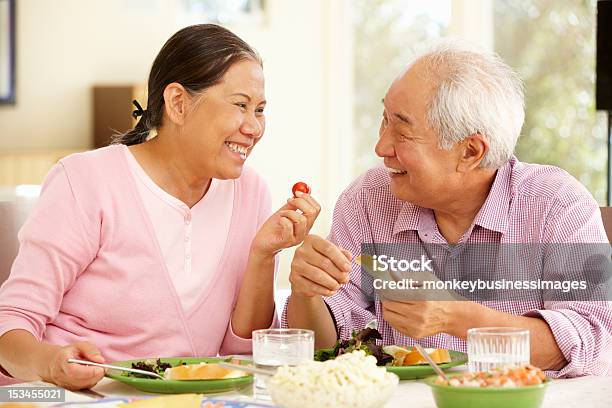 Senior Pareja Compartir Una Comida Asiática En Casa Foto de stock y más banco de imágenes de Tercera edad