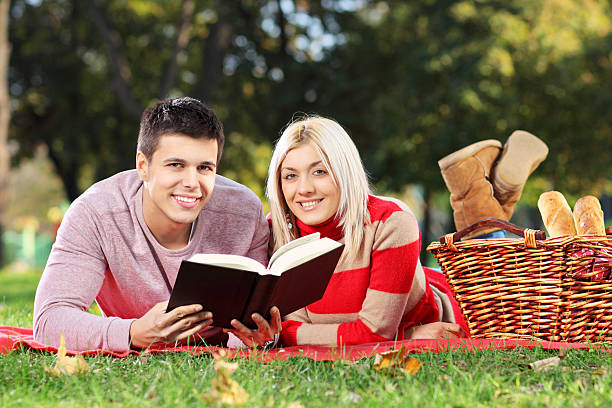 istock Loving couple reading a book in park 153459744