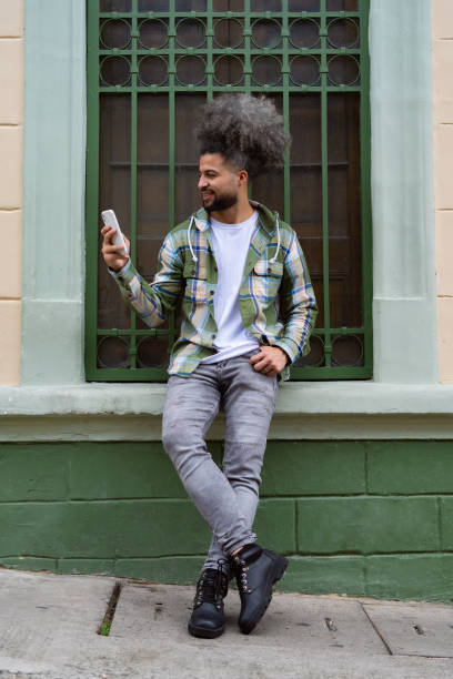 istock Cheerful man using smart phone on street sidewalk. 1534601595