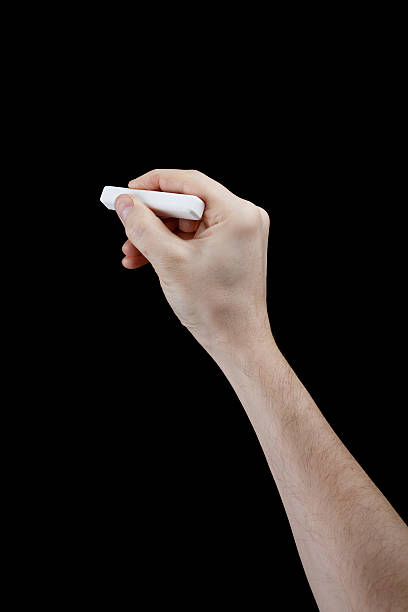 istock hand with piece of chalk isolated on black 153460206