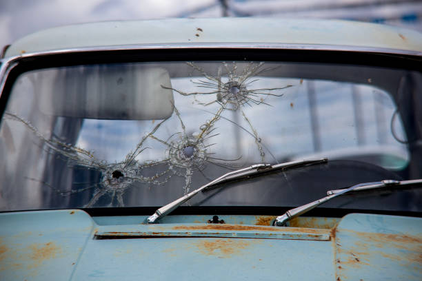 istock Bullet holes on windshield old car 1534607437