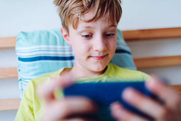 istock School age boy playing video game using mobile at home lying down on bed 1534613719