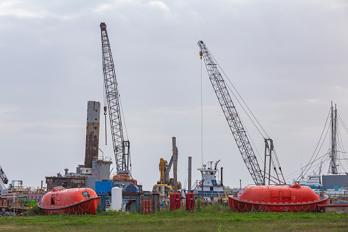 Cranes, lifeboats, life rafts, shipping equipment, at an old deserted port in Luisiana