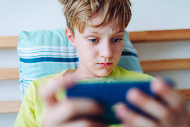istock School age boy playing video game using mobile at home lying down on bed 1534633490