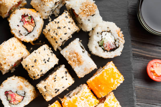 istock Flat lay of various sushi rolls placed on stone board. 1534643415
