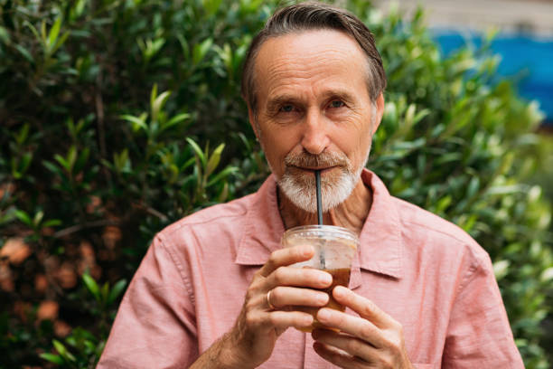 istock Senior man drinking a smoothie and looking at camera while standing on the park 1534662908