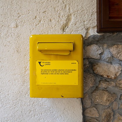 Moscenice, Croatia. July 10, 2023.  the yellow box of the Croatian post office in the center of the village