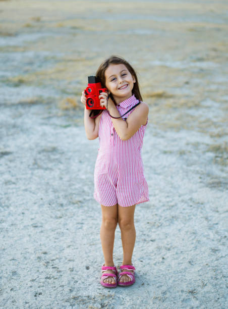 istock Cute little girl posing with a vintage camera 1534721942