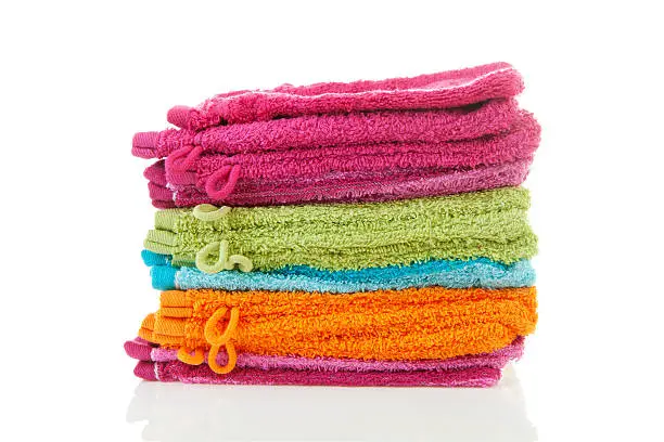 Pile of colorful washclothes over white background