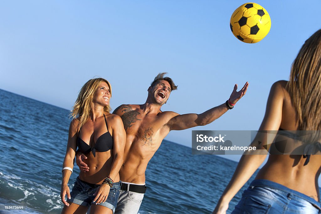Amici avendo divertimento sulla spiaggia con palla. - Foto stock royalty-free di Donne