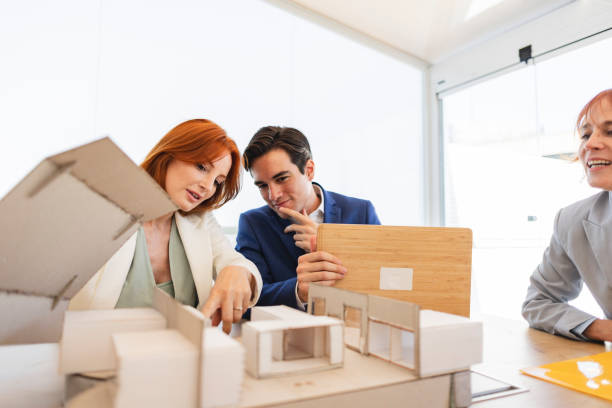 istock architects with a model in office, studying the next construction with coworkers 1534736509