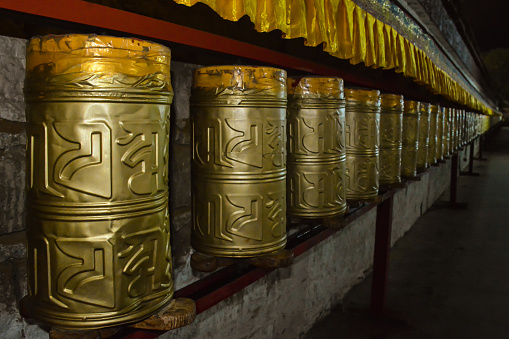 Night view of buddhist tibetian prayer wheels next to the Potala Palace in Lhasa. Tibet, China