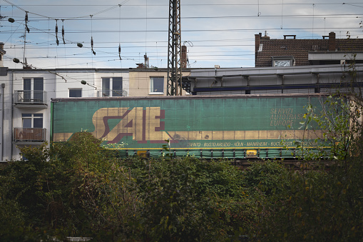 Picture of a sign with the logo of Servizi Autotrasporti Europei on a container being shipped by rail in Cologne, Germany.SAE is a container shipping and logistics service company.