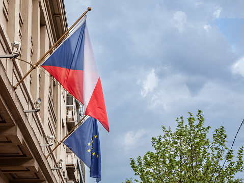 Picture of the flag of Czech Republic and the flag of the EU together in front of a building of Prague. Czechuia is one of the main members of the European union since it joined the community in 2004.
